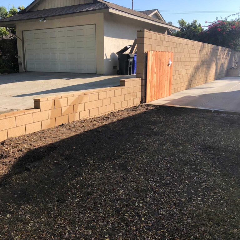 A driveway with a fence and a garage door.