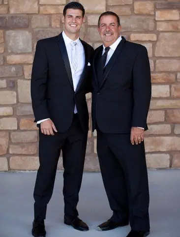 Two men in suits posing for a picture.