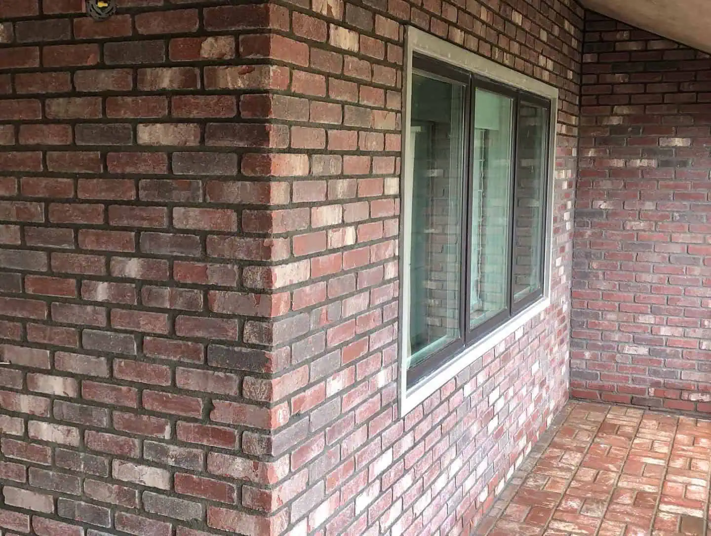A brick wall with windows and a window sill.