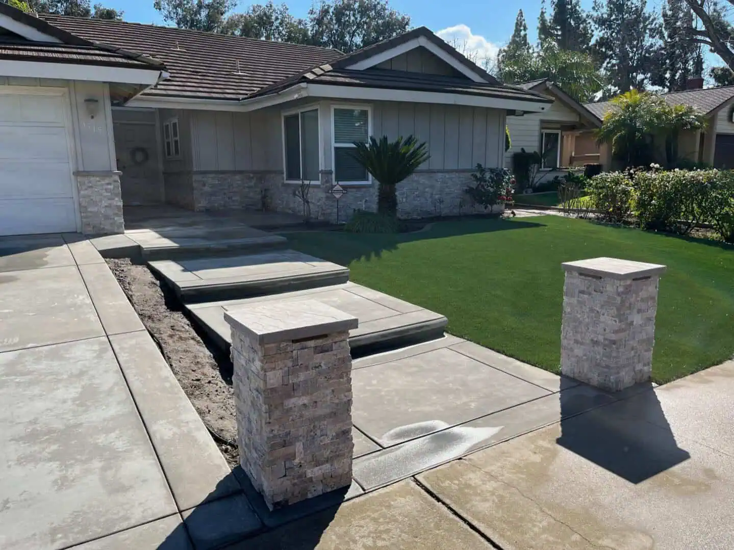 A house with a lawn and concrete steps.