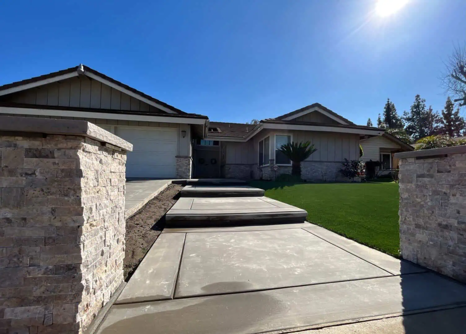 A driveway with concrete steps leading to the front of a house.
