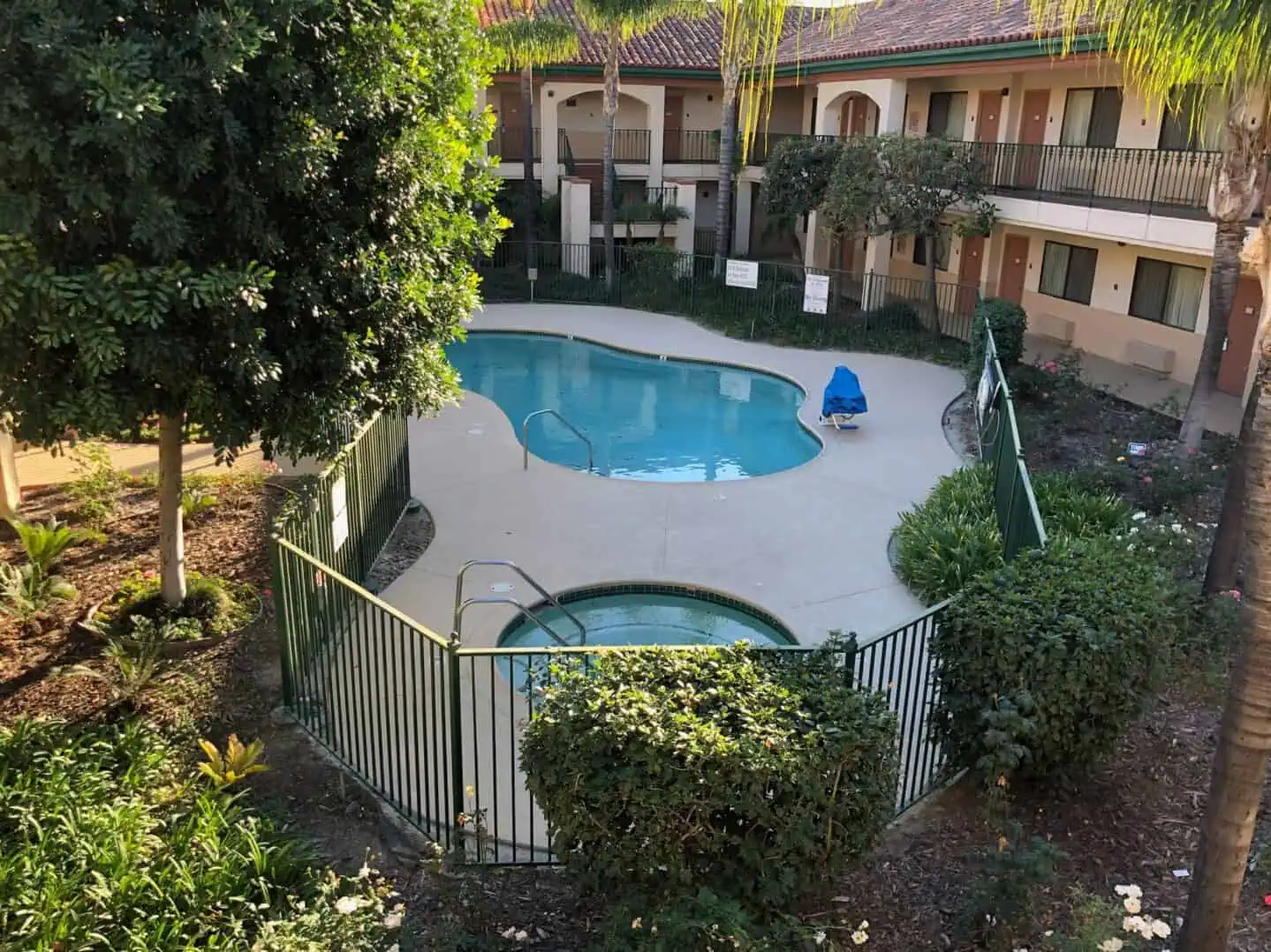 A pool with a fence around it and trees in the background.