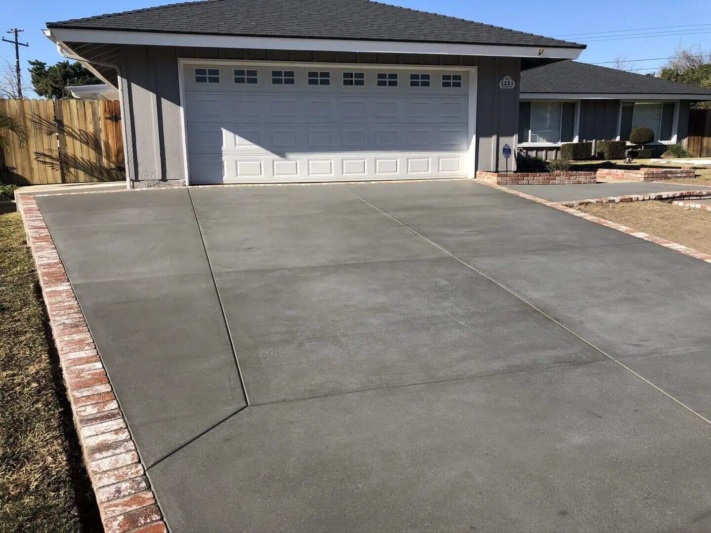 A driveway with concrete and brick around it.