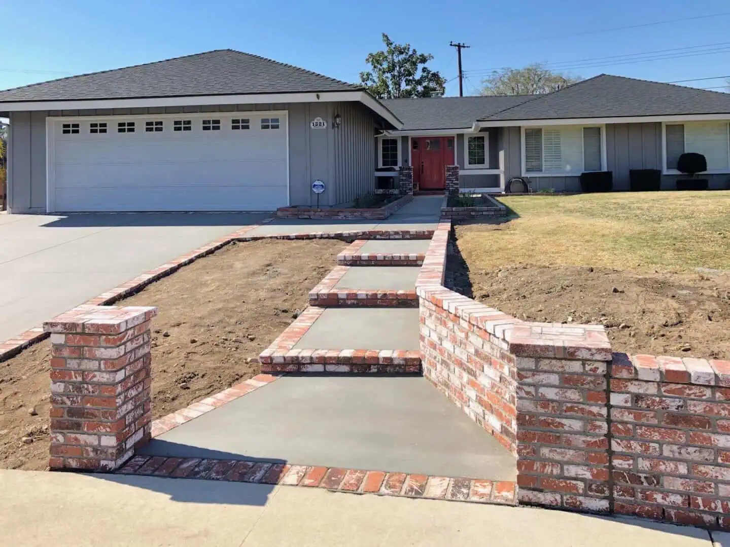 A driveway with brick steps and concrete walls.