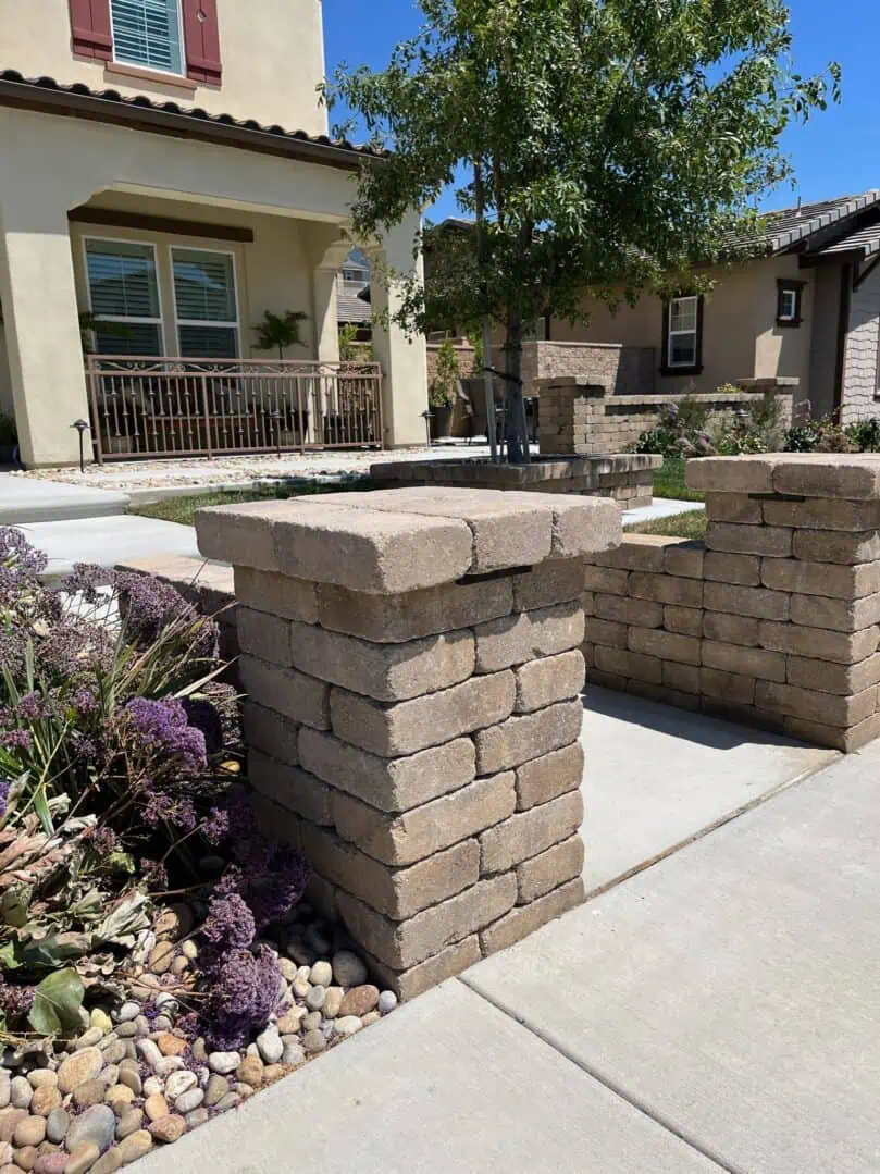 A brick wall with two pillars on the side of it.