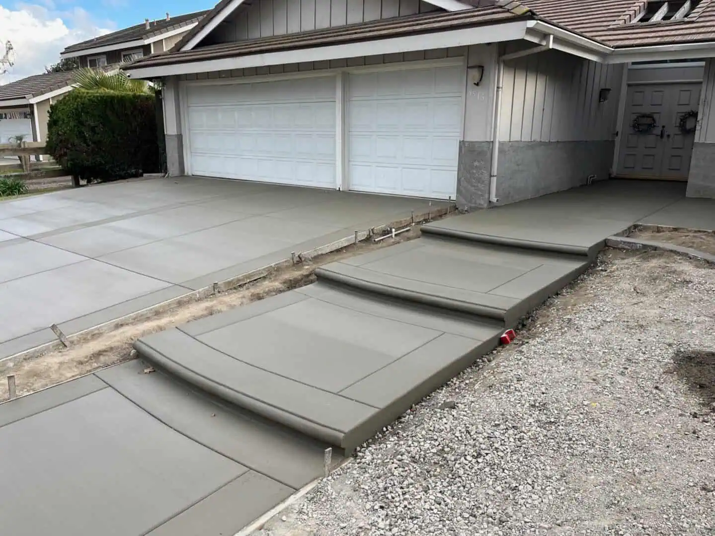 A concrete driveway with steps leading to the garage.