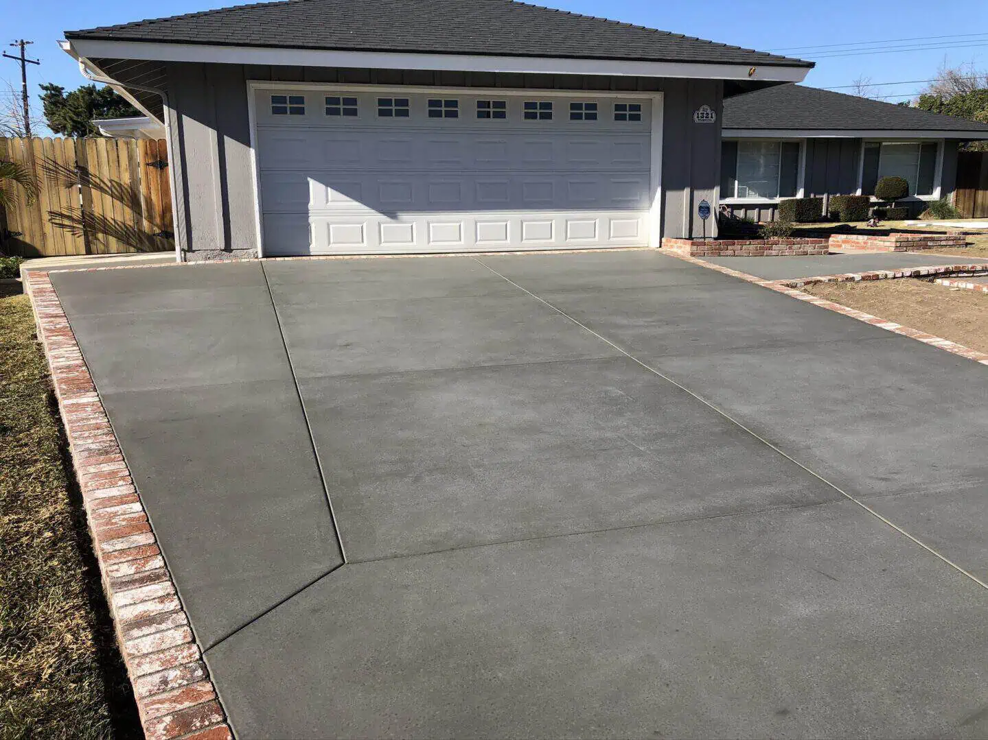 A driveway with concrete and brick around it.