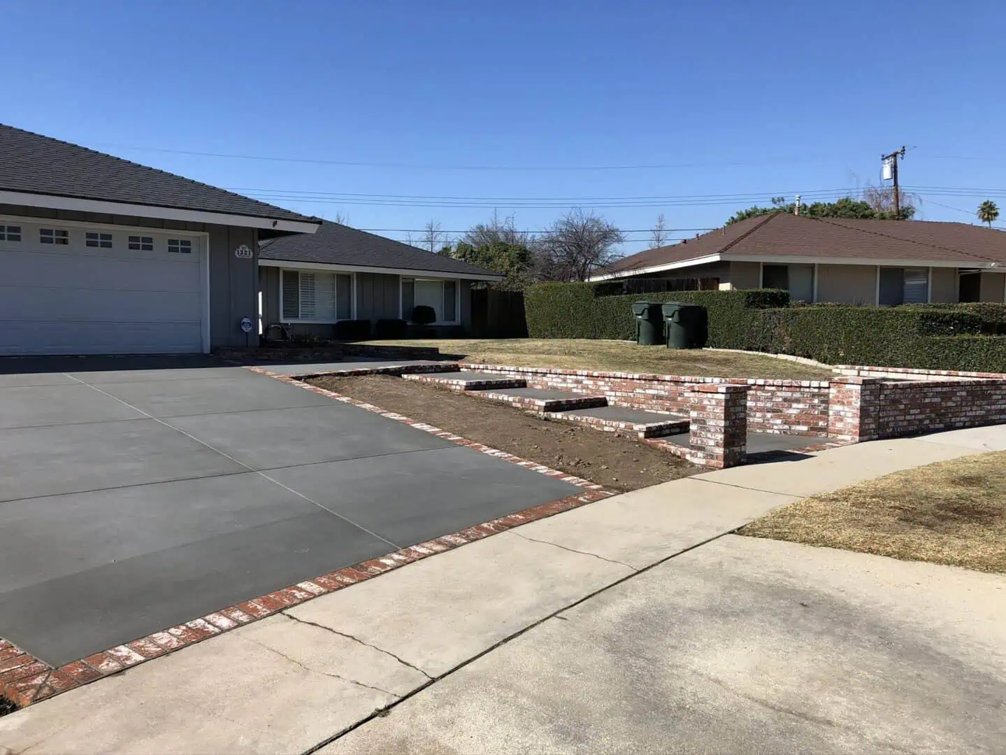A driveway with brick steps and concrete wall.