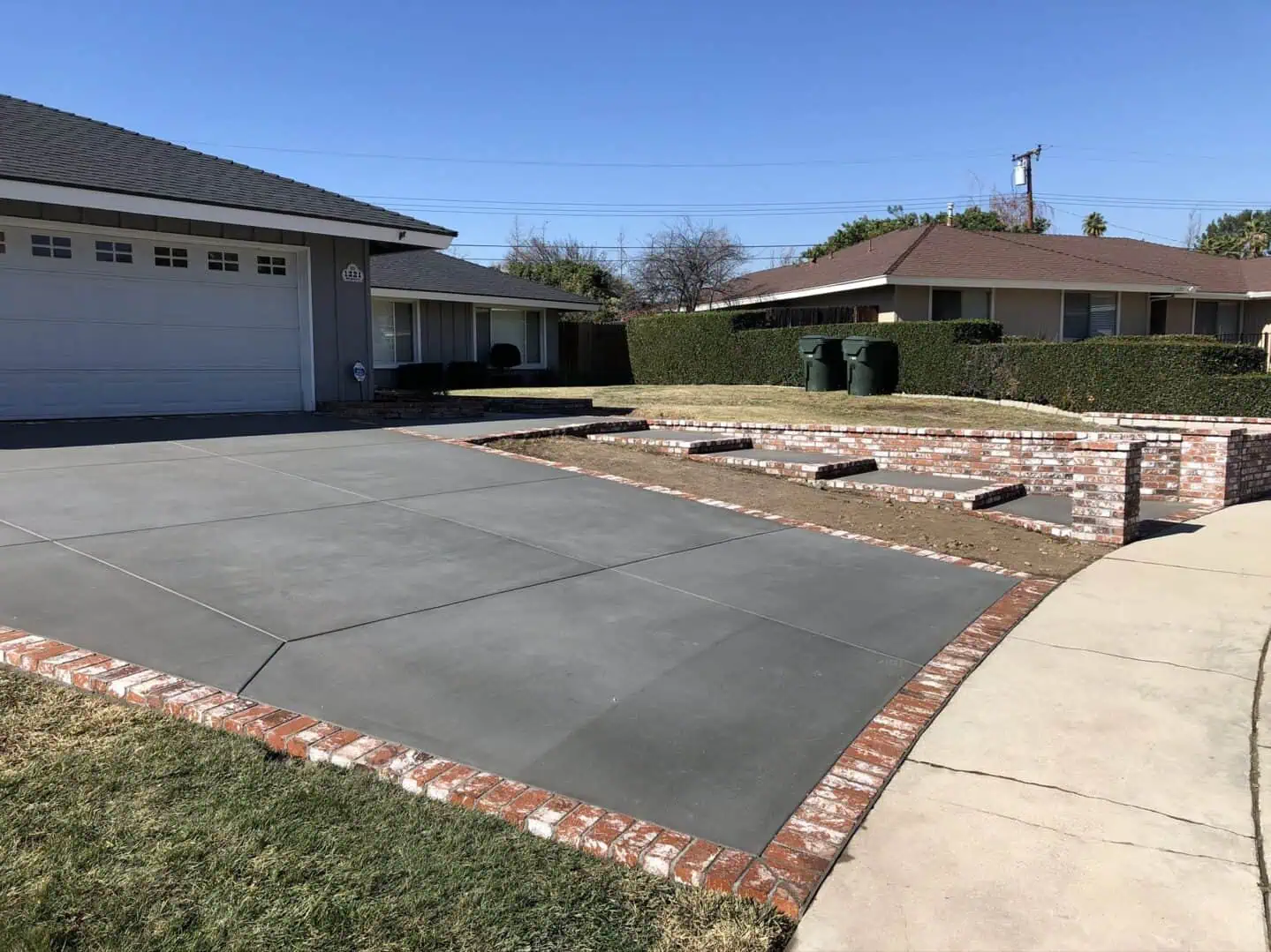 A driveway with brick edging and concrete.