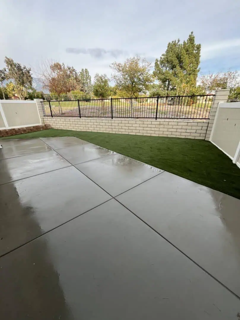 A patio with grass and concrete in the middle of it.