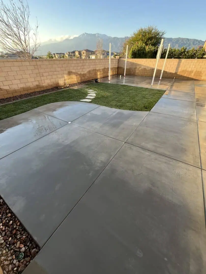 A concrete patio with grass growing in it.