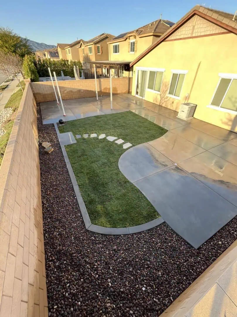 A backyard with a lawn and a walkway.