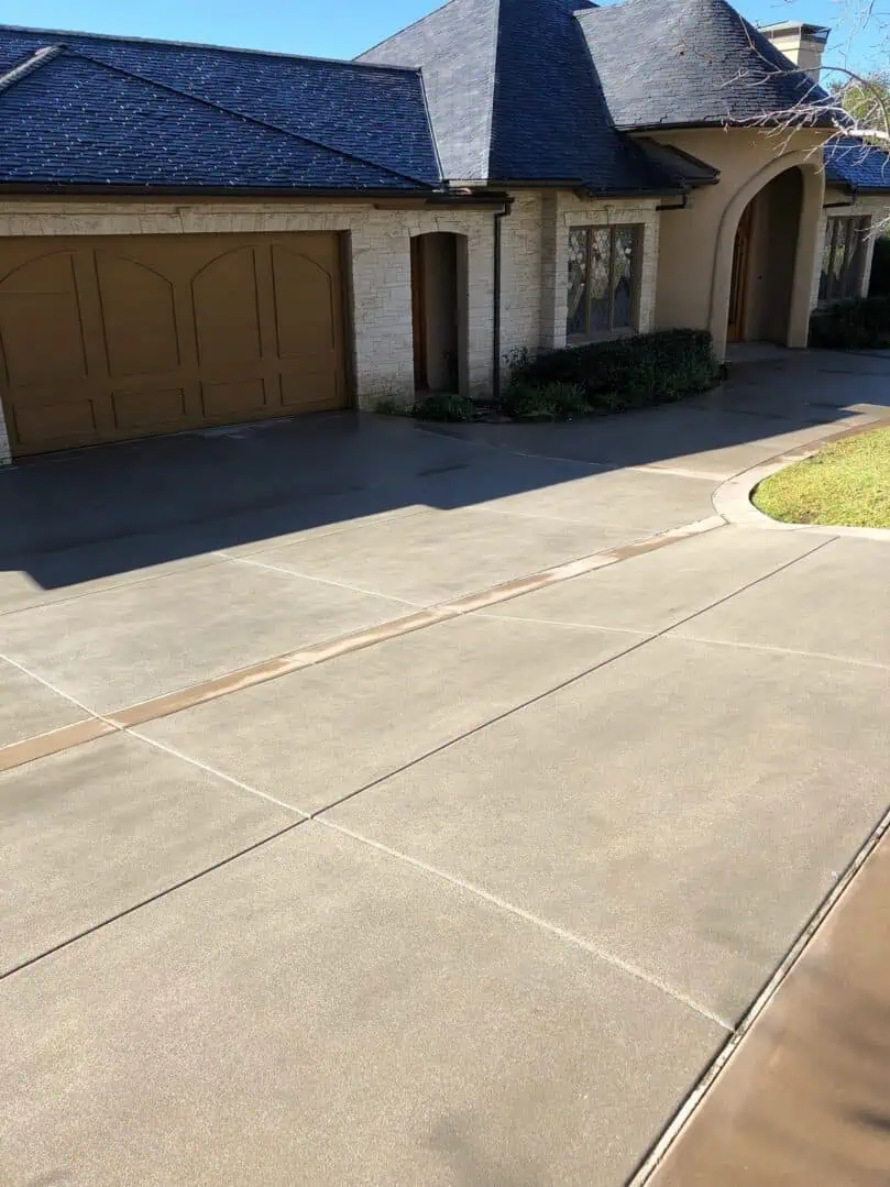 A driveway with a garage door and concrete.