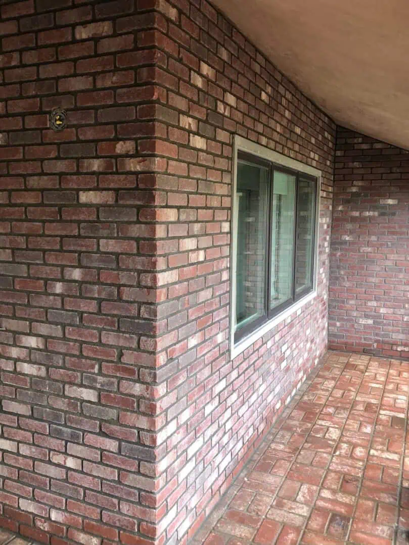 A brick wall with windows and a window sill.