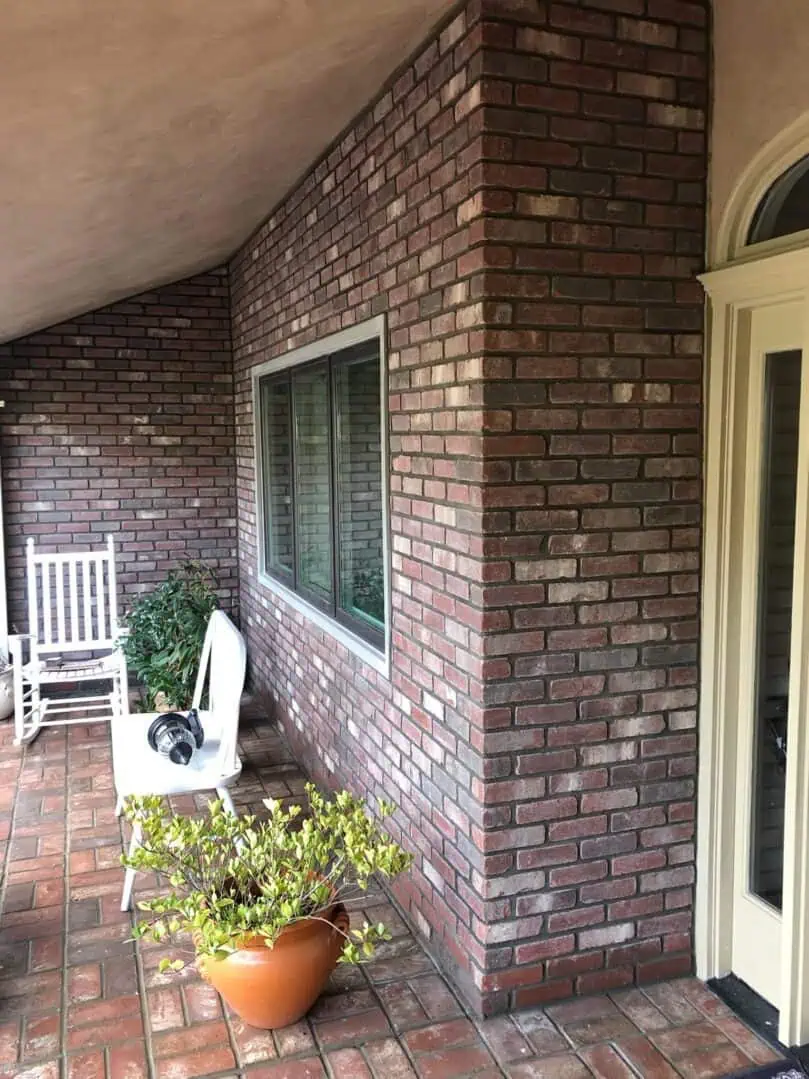 A brick wall with a window and door.