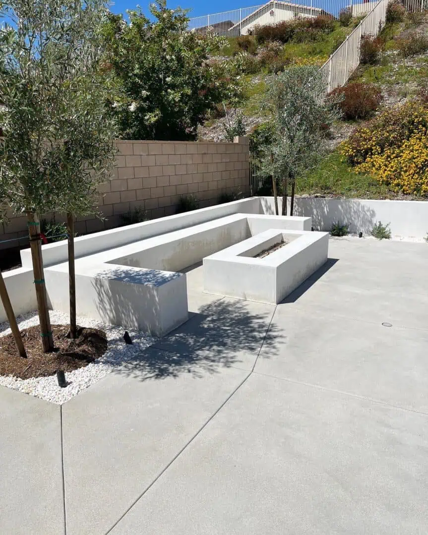 A concrete bench with a fire pit in the middle of it.