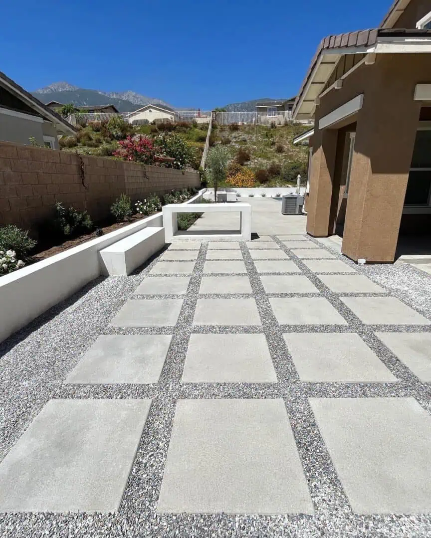 A patio with a large cement floor and gravel.