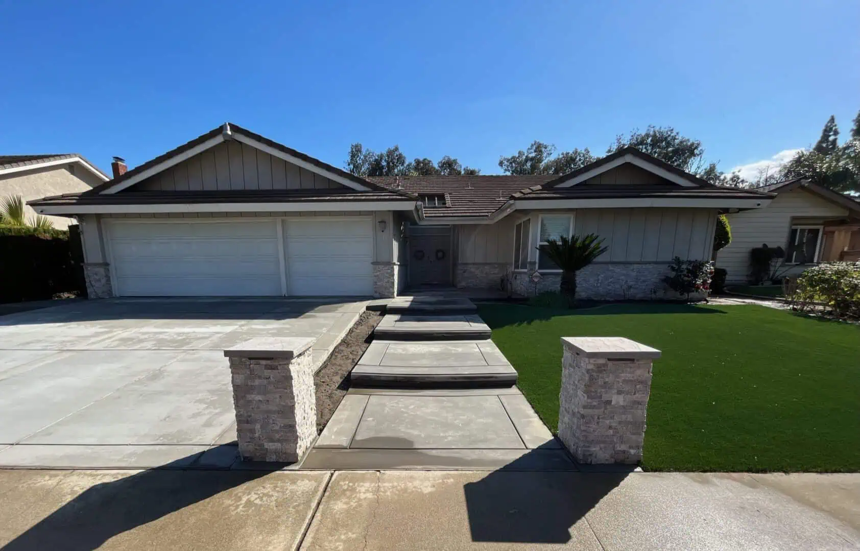 A house with a driveway and lawn in front of it