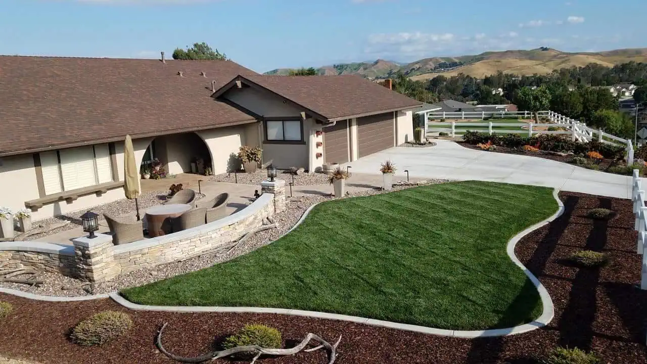 A large house with a lot of grass on the front lawn.