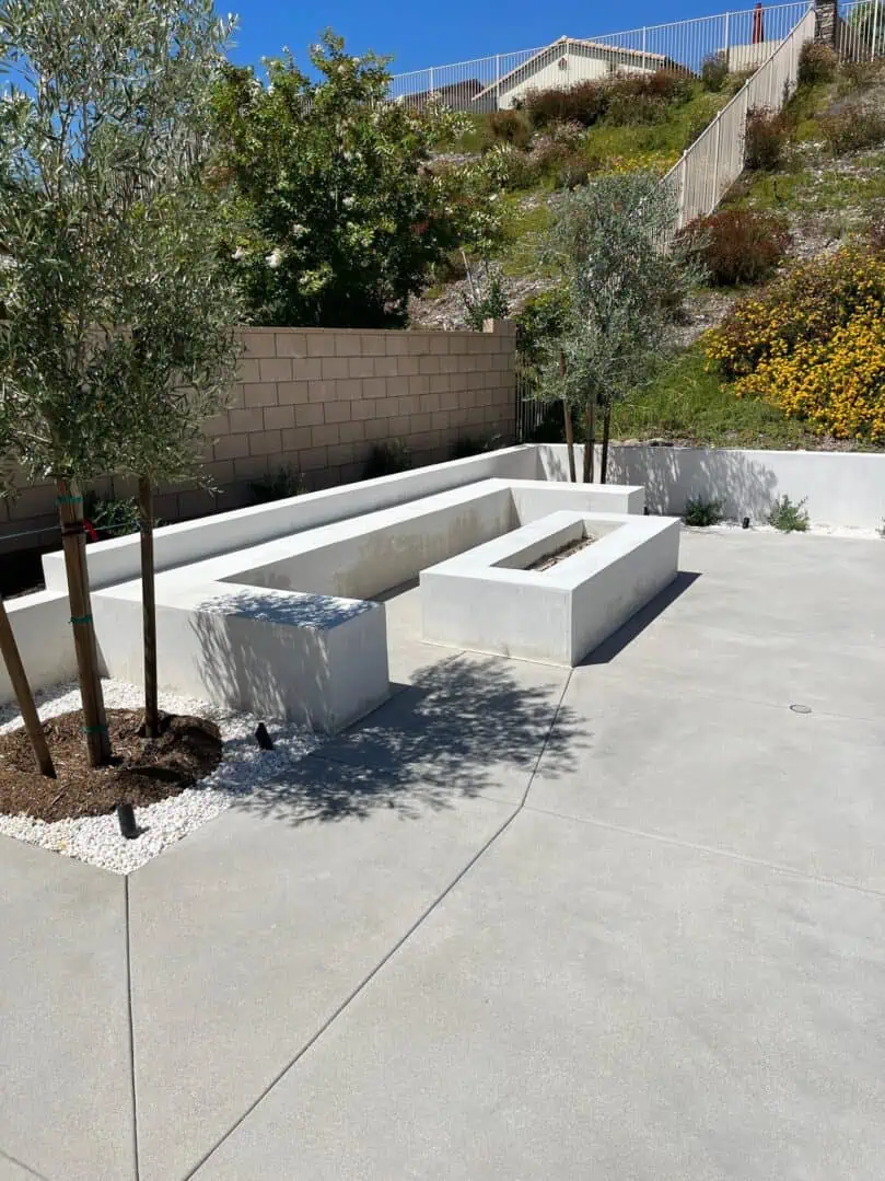 A concrete bench with trees in the background