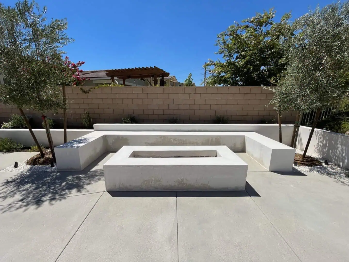 A concrete bench with a fire pit in the middle of it.