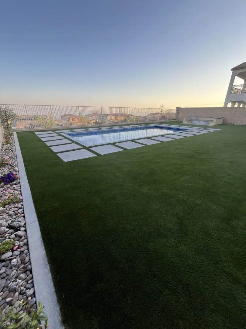 A pool and grass area on the roof of a building.