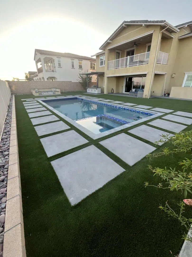 A pool with grass and concrete in the middle of it