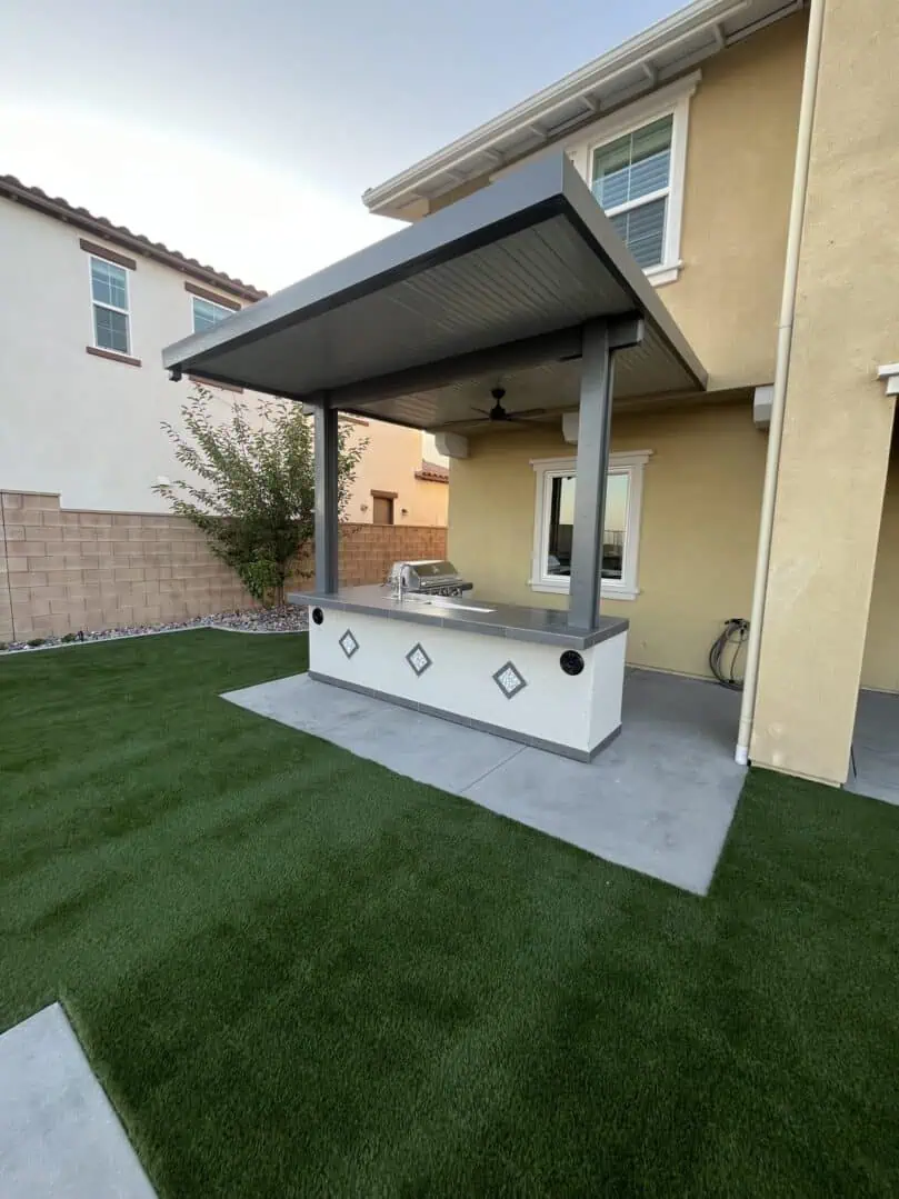 A backyard with grass and an outdoor grill.