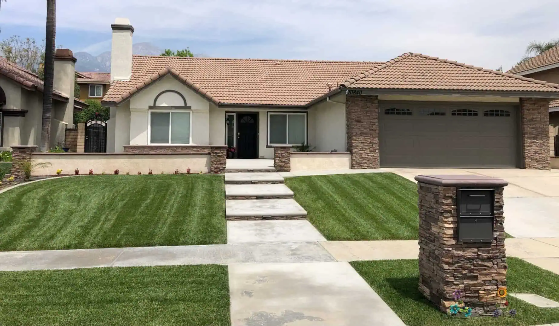 A house with grass and concrete steps leading to the front door.