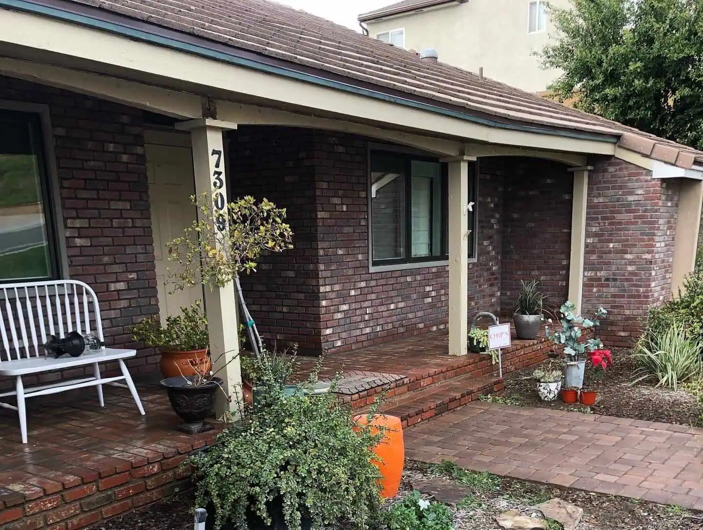 A brick house with a porch and patio.