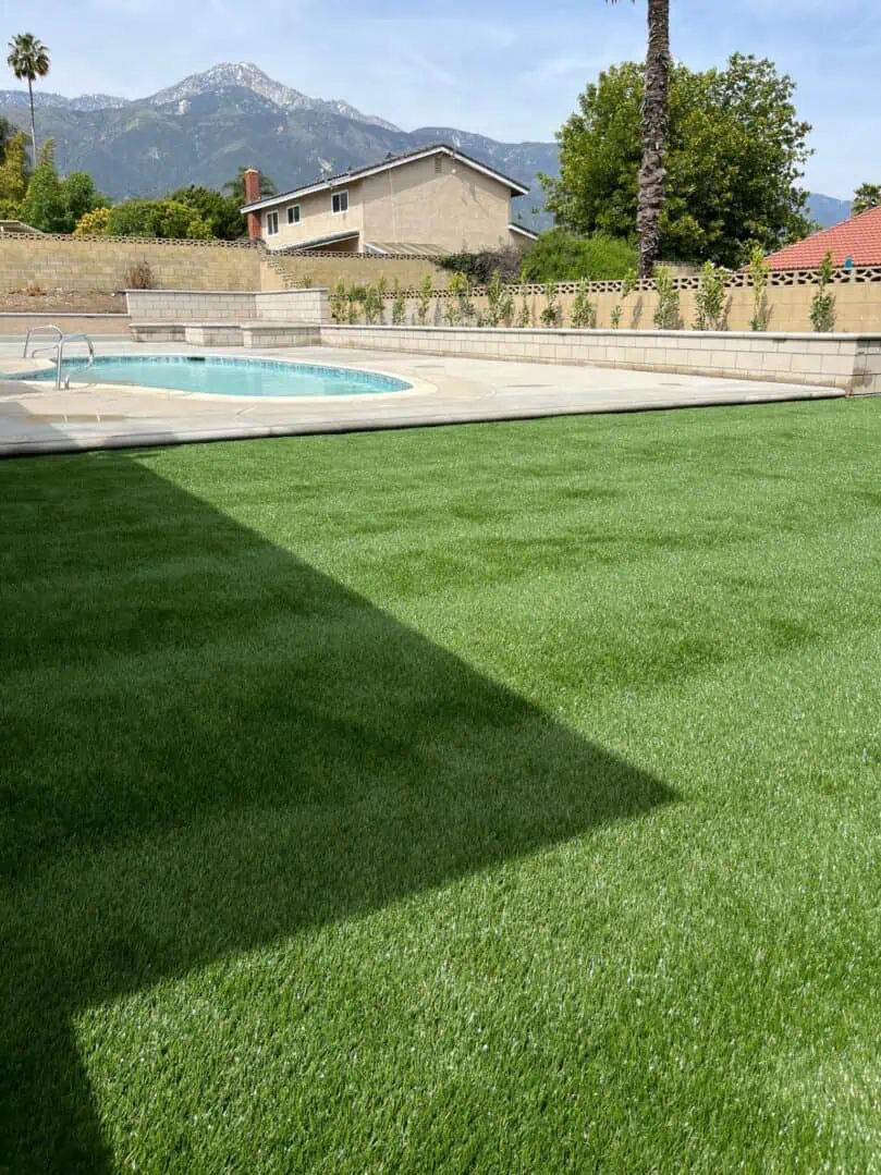 A pool and some grass in the yard