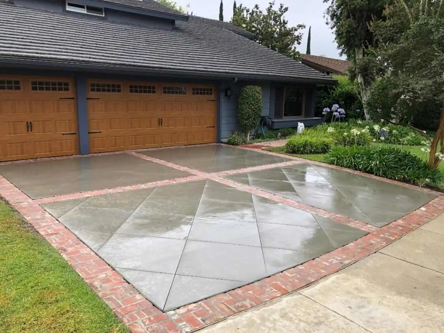 A driveway with a large concrete slab in the middle of it.
