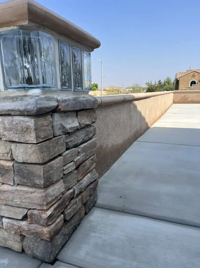 A stone wall with a glass window on the side.