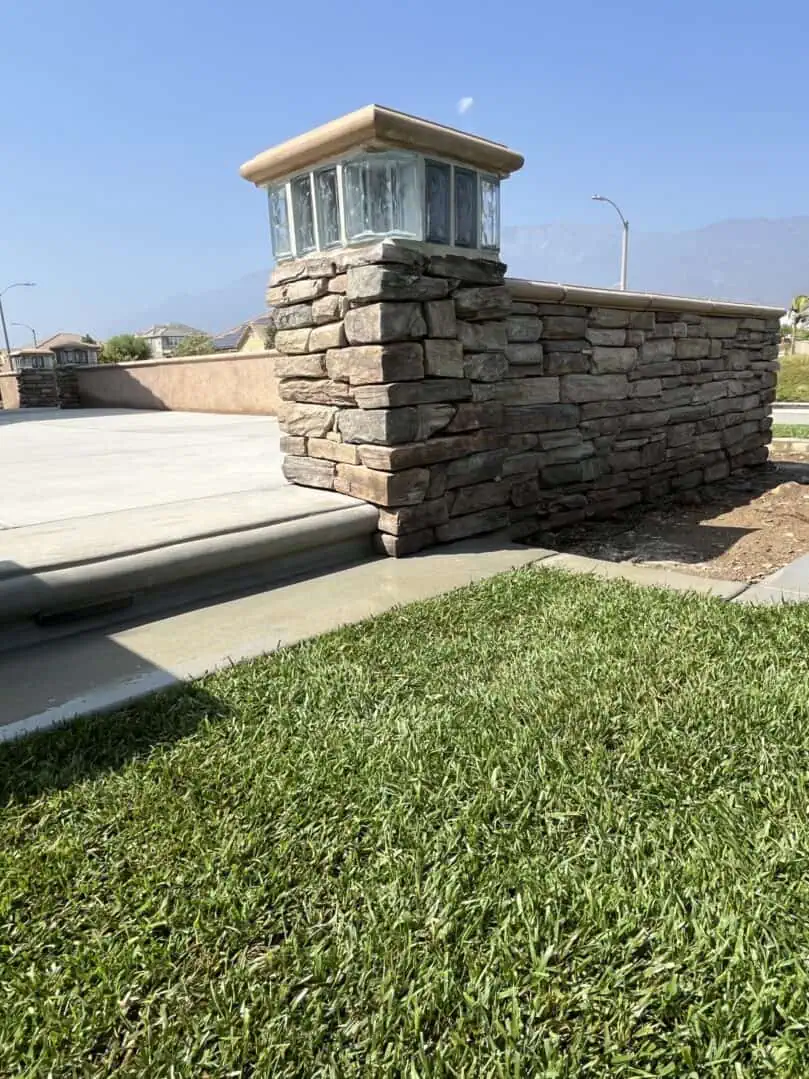 A stone wall with grass growing on it.