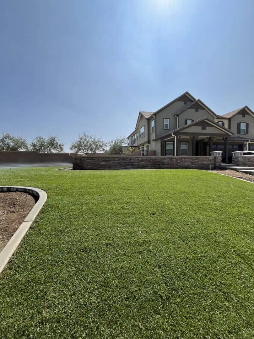 A large yard with grass and a house in the background.