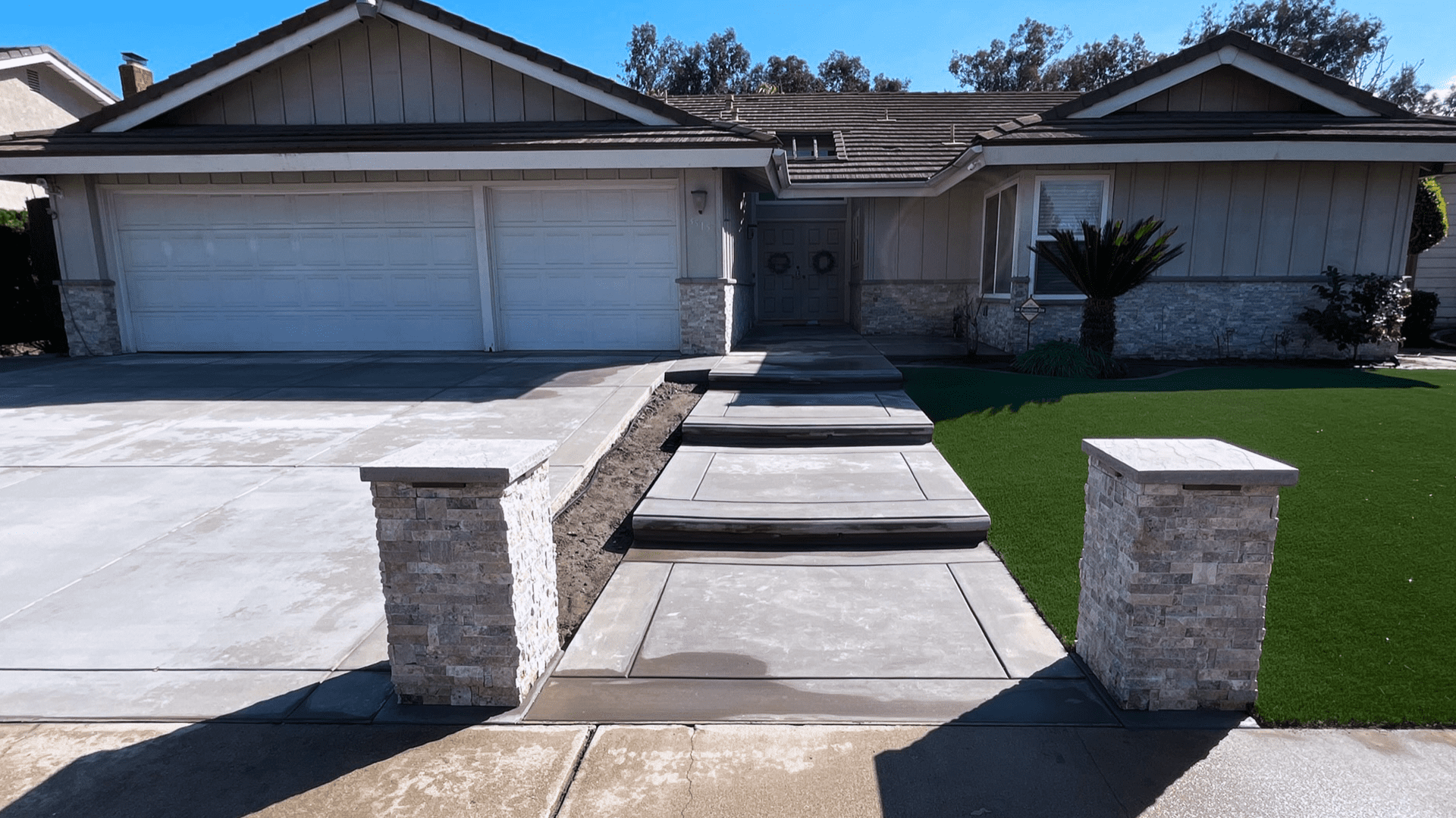 A house with steps leading to the driveway.