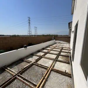 Construction site with wooden forms and gravel.