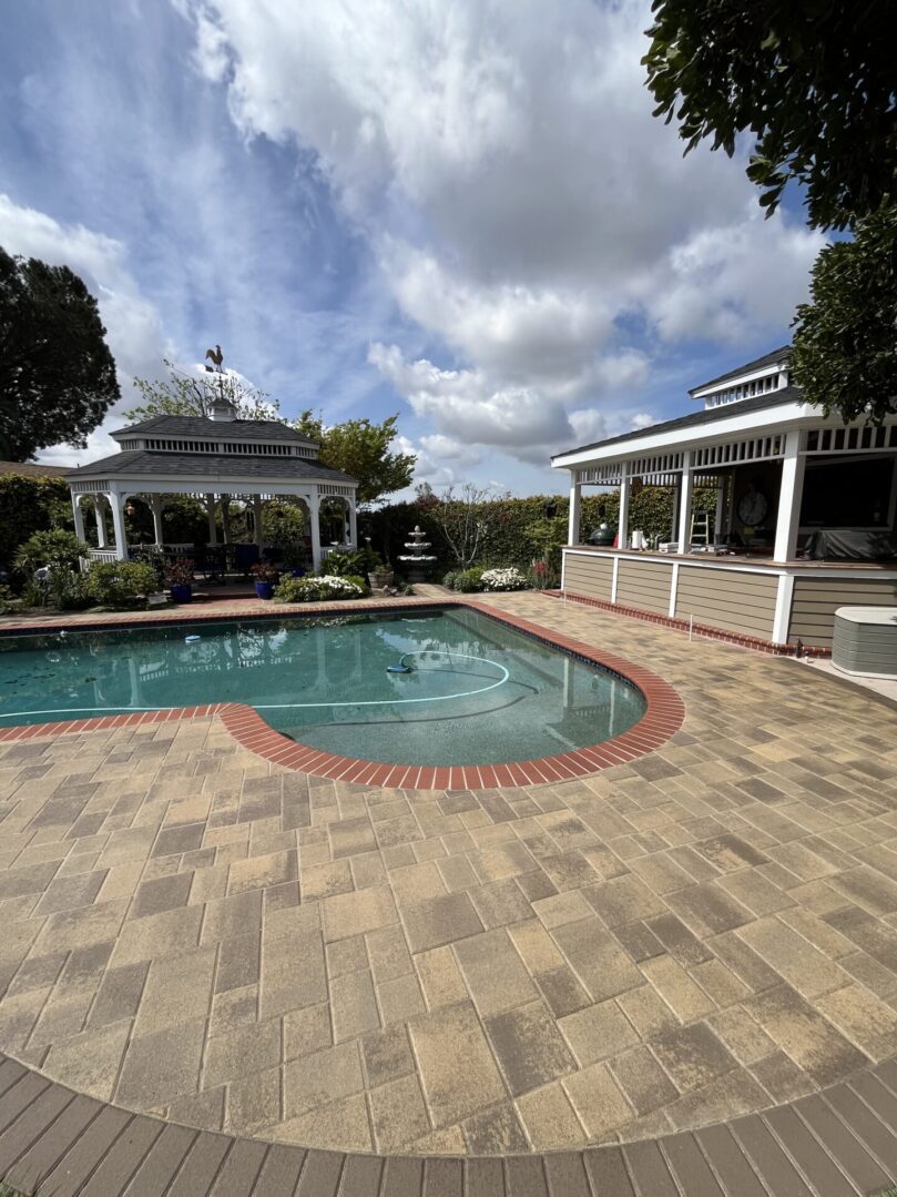 Backyard pool with patio and gazebo.
