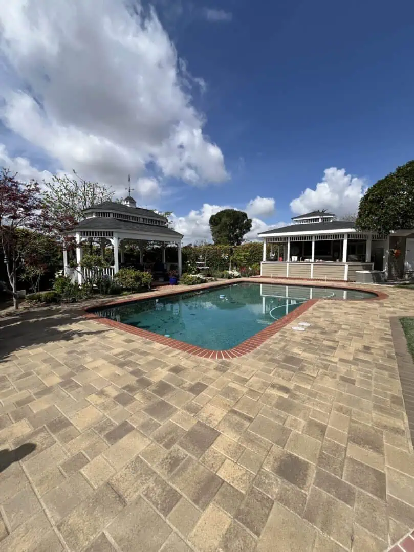 Outdoor pool with pavilions and cloudy sky.
